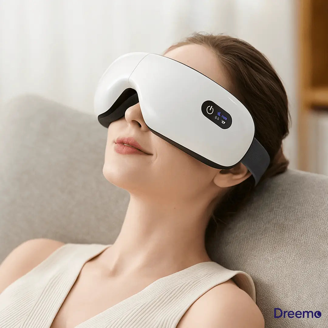 Woman reclining with Dreemo Elixir One™ Eye Massager in white, enjoying air pressure and heat therapy to relieve eye fatigue and tension.